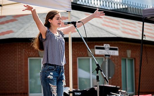 young girl singing on stage