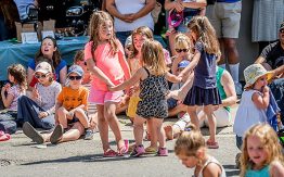 families with children sitting on the street, little girls dancing
