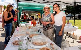 two women, vendors with pies, smiling