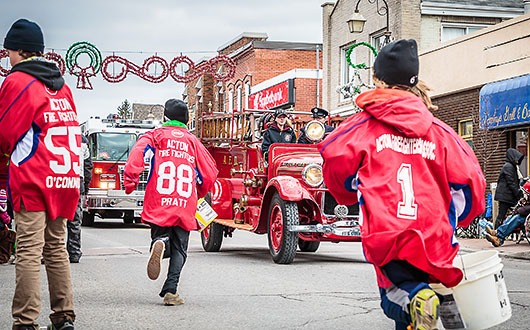 old red fire truck in the parade, boys in red jerseys running