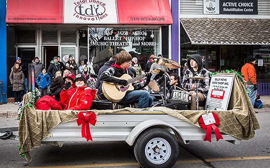 youth band playing instruments, sitting on an open trailer in Santa Claus parade