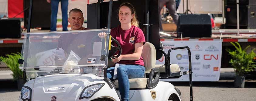 man and girl riding golf cart at the festival