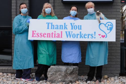 People standing in line holding "Thank You Essential Workers" sign.